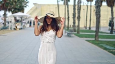 Beyaz elbise ve pamela şapka yürüyüş giyen Pretty kadın