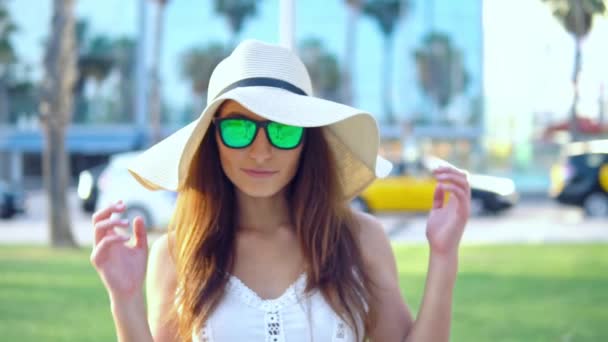 Pretty woman wearing white dress and pamela hat walking — Stock Video