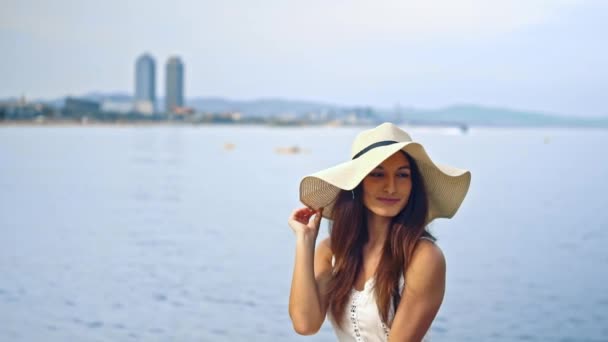 Mujer bonita con vestido blanco y sombrero de pamela sentado — Vídeo de stock