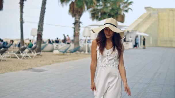 Mulher bonita vestindo vestido branco e chapéu pamela andando — Vídeo de Stock