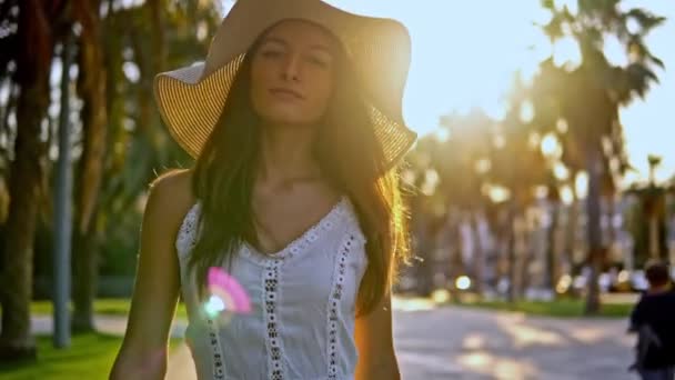 예쁜 여자 입고 화이트 드레스 와 파멜라 모자 산책 — 비디오
