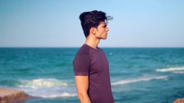 Taş Sahilde duran genç atletik adam. Sağlık kavramı