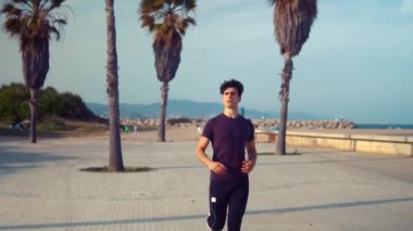 Plaja yakın palmiye ağacı parkta çalışan genç atletik adam