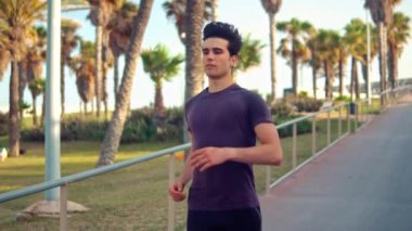 Plaja yakın palmiye ağacı parkta çalışan genç atletik adam