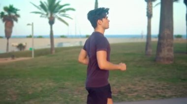 Plaja yakın palmiye ağacı parkta çalışan genç atletik adam