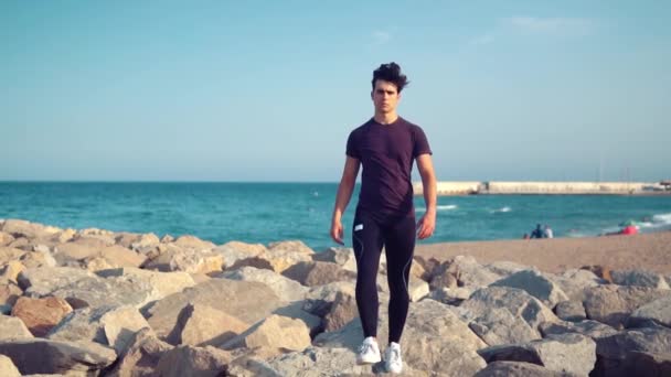 Jeune homme sportif marchant sur la plage. Concept de santé — Video