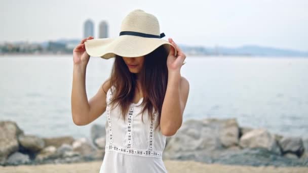 Mujer bonita con vestido blanco y sombrero de pamela caminando — Vídeo de stock