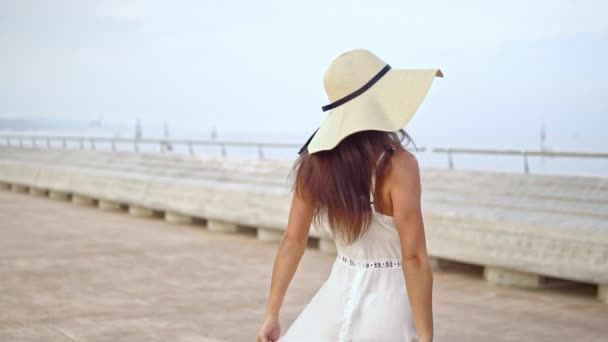 Jolie femme en robe blanche et chapeau pamela marche — Video