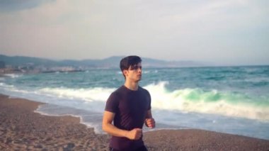 Sahilde koşan genç atletik adam. Sağlık kavramı