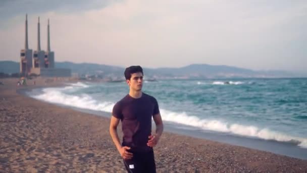 Jonge atletische man die op het strand loopt. Health concept — Stockvideo