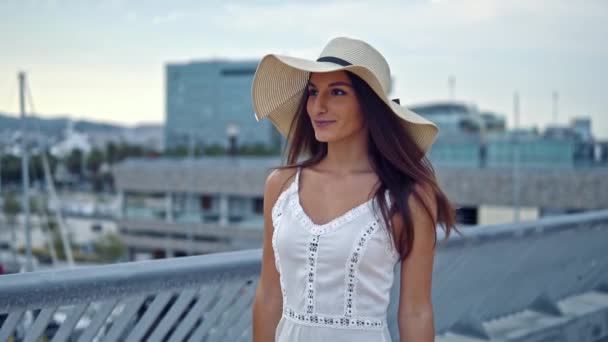 Jolie femme en robe blanche et chapeau pamela marche — Video