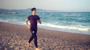 Sahilde koşan genç atletik adam. Sağlık kavramı
