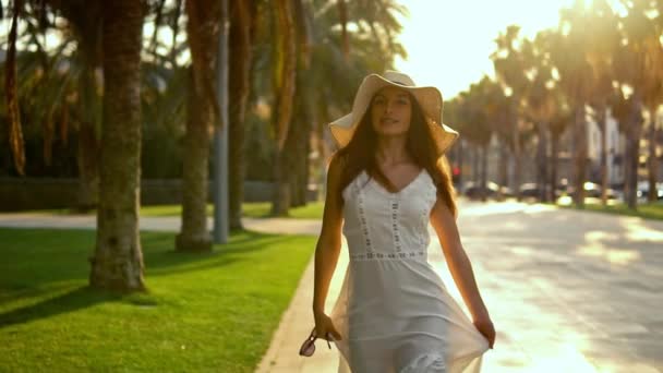 Pretty woman wearing white dress and pamela hat walking — Stock Video