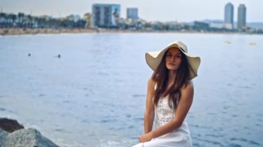 Beyaz elbise ve pamela şapka oturan pretty kadın