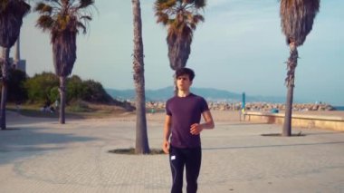 Plaja yakın palmiye ağacı parkta çalışan genç atletik adam