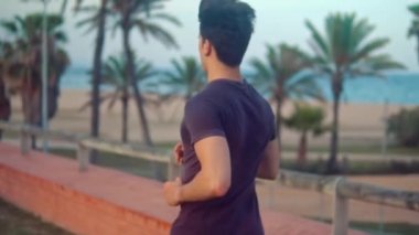 Plaja yakın palmiye ağacı parkta çalışan genç atletik adam