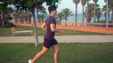 Plaja yakın palmiye ağacı parkta çalışan genç atletik adam