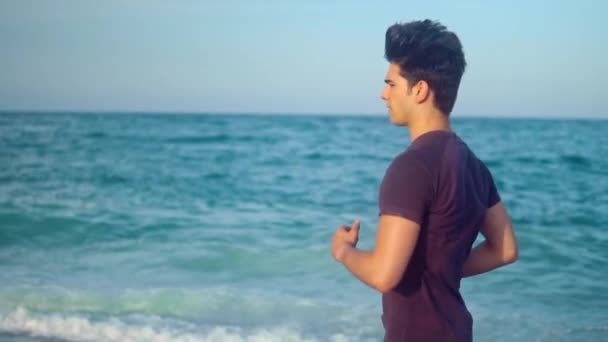 Jonge atletische man die op het strand loopt. Health concept — Stockvideo
