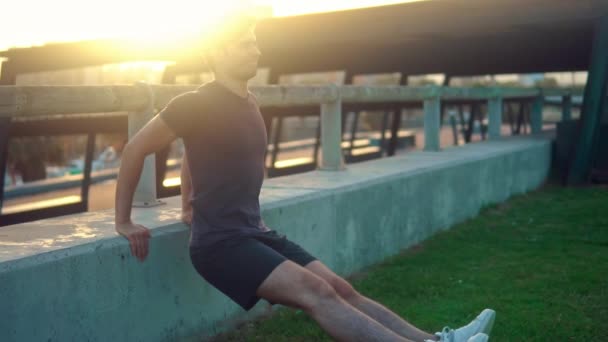 Hombre atlético joven haciendo ejercicios de flexiones en el parque — Vídeos de Stock