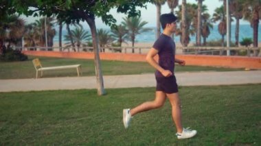 Plaja yakın palmiye ağacı parkta çalışan genç atletik adam