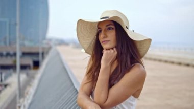 Beyaz elbise ve pamela şapka ayakta giyen güzel kadın