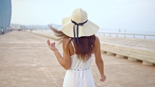 Mulher bonita vestindo vestido branco e chapéu pamela andando — Vídeo de Stock