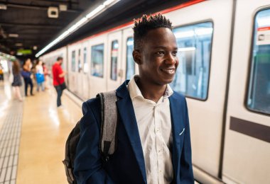 Mavi takım elbise ve sırt çantası giyen Afro-Amerikalı işadamı