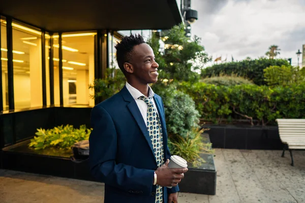 Hombre de negocios afroamericano con traje azul bebe café cerca de la oficina —  Fotos de Stock