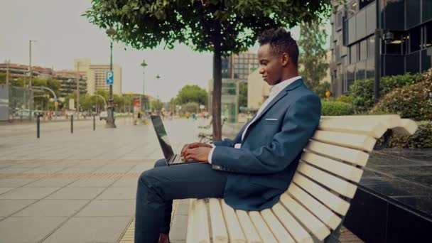 African American affärsman Holding laptop anteckningsbok bär blå kostym — Stockvideo