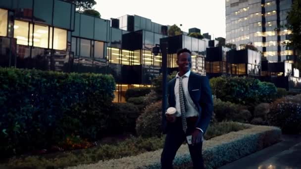 Uomo d'affari afroamericano in possesso di cellulare con indosso abito blu — Video Stock