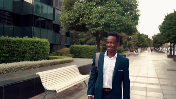 Hombre de negocios afroamericano con traje azul caminando — Vídeos de Stock