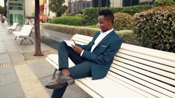 Affärsman läser dokument eller anteckningsbok bär blå kostym nära kontoret — Stockvideo