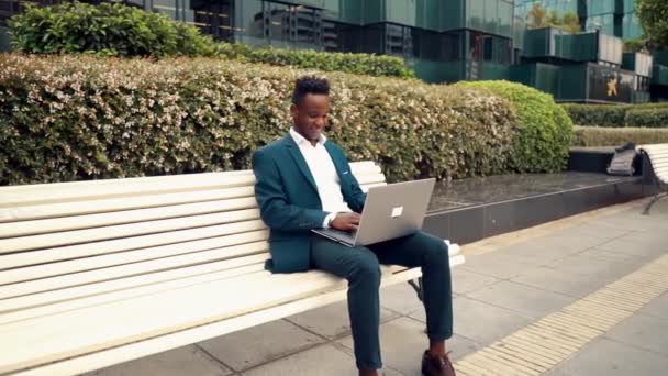 青いスーツを着てノートパソコンを持つアフリカ系アメリカ人のビジネスマン — ストック動画