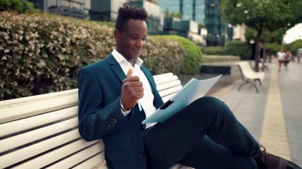 Hombre de negocios lee documentos o cuaderno con traje azul cerca de la oficina — Vídeos de Stock