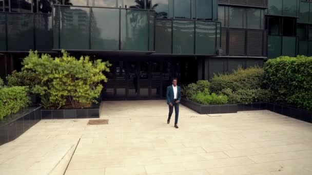 Αφρικανός Αμερικανός επιχειρηματίας φορώντας μπλε κοστούμι περπάτημα — Αρχείο Βίντεο