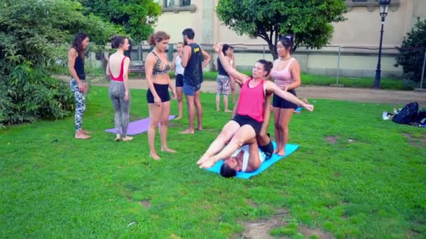 Eine Gruppenstunde über Akroyoga, die im Park stattfindet — Stockvideo