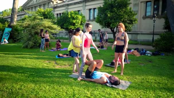 Eine Gruppenstunde über Akroyoga, die im Park stattfindet — Stockvideo