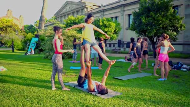 Lekcja grupowa na akroyoga, która odbywa się w parku — Wideo stockowe