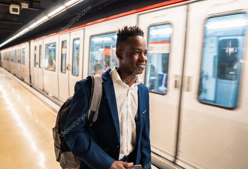 African American businessman wearing blue suit and backpack