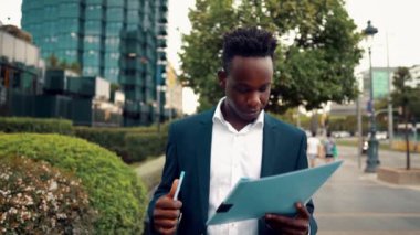 işadamı ofis yakınında mavi takım elbise giyen belge veya defter okur