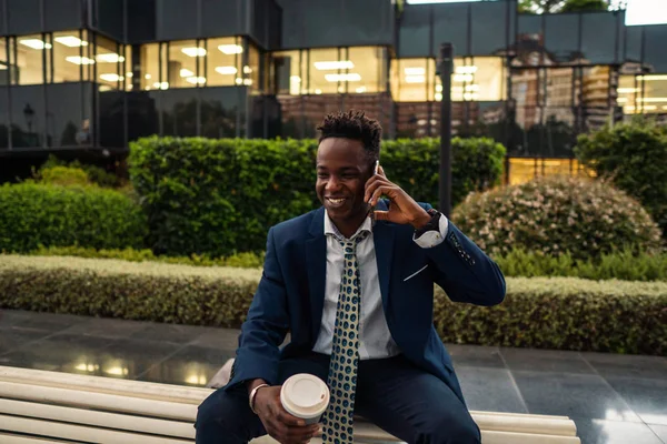 Αφρικανός Αμερικανός επιχειρηματίας κρατώντας κινητό τηλέφωνο φορώντας μπλε κοστούμι — Φωτογραφία Αρχείου