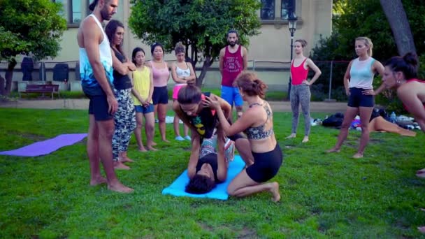 Een groepsles over acroyoga die plaatsvindt in Park — Stockvideo