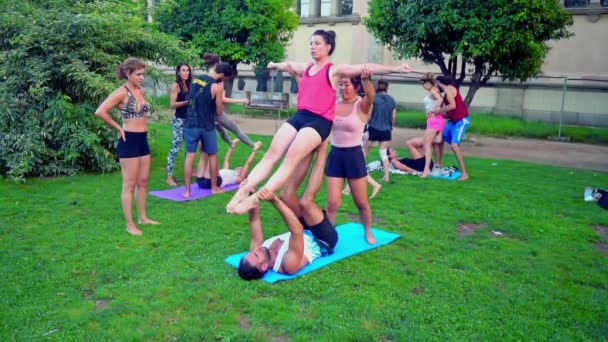 Lekcja grupowa na akroyoga, która odbywa się w parku — Wideo stockowe