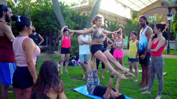 Een groepsles over acroyoga die plaatsvindt in Park — Stockvideo