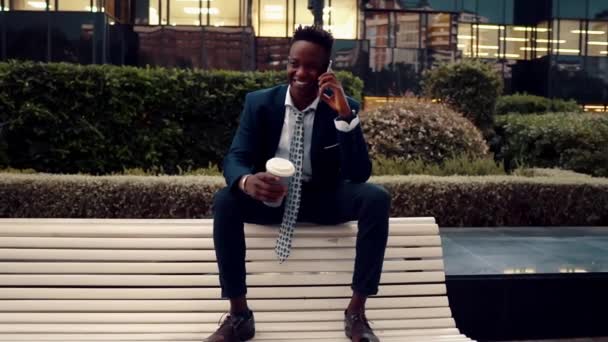 African American businessman holding mobile phone wearing blue suit — Stock Video