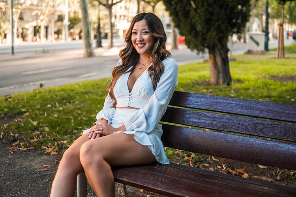 Menina asiática bonita em vestido branco sorrindo no parque — Fotografia de Stock