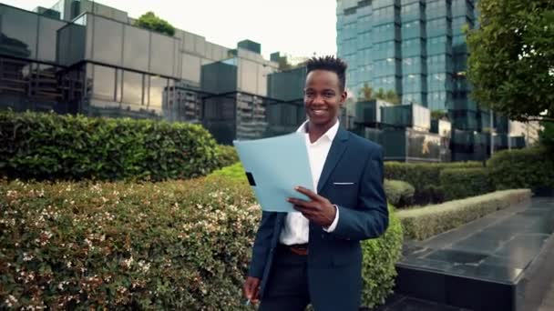 Geschäftsmann liest Dokumente oder Notizbuch im blauen Anzug in der Nähe des Büros — Stockvideo