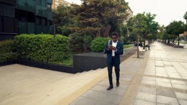 Mavi takım elbise giyen cep telefonu tutan Afro-Amerikalı işadamı