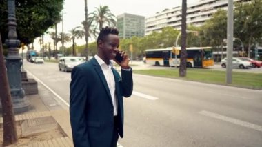 Mavi takım elbise giyen Afro-Amerikan işadamı yürüyor