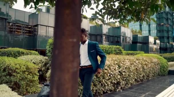 African American zakenman draagt blauw pak wandelen — Stockvideo